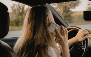 Conducente che utilizza lo smartphone mentre guida, comportamento pericoloso che comporta perdita punti patente